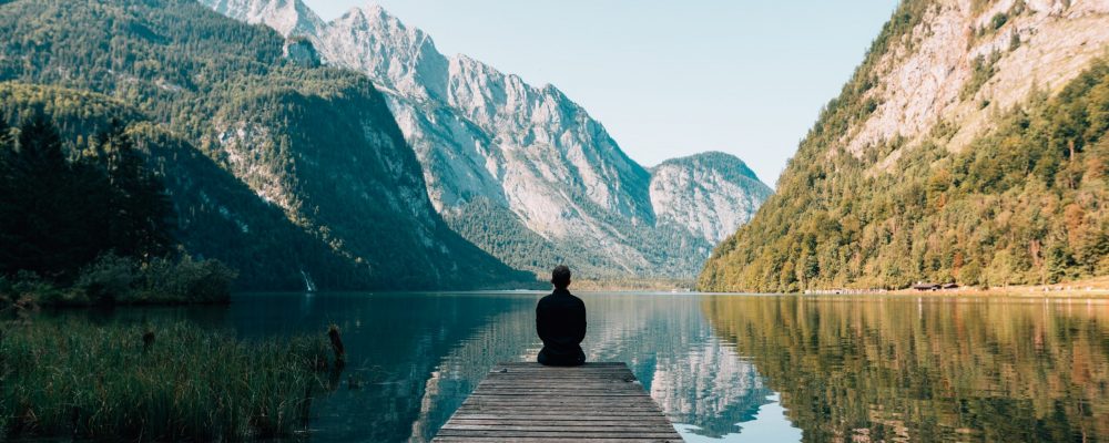 man sitting on gray dock